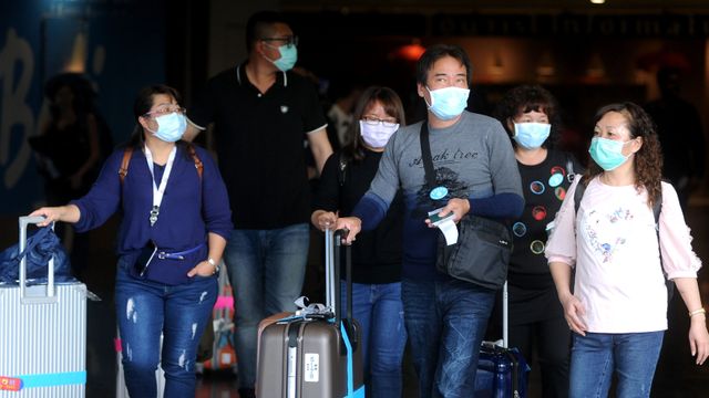 Sejumlah penumpang pesawat mengenakan masker di area Terminal Kedatangan Internasional Bandara Internasional I Gusti Ngurah Rai, Bali, Jumat (31/1/2020). Foto: ANTARA FOTO/Fikri Yusuf