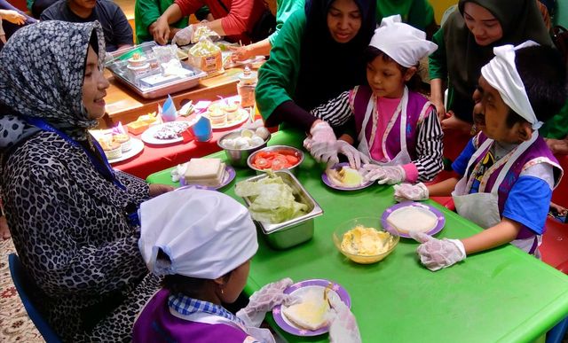 Ketua YKAKI (kiri) bersama anak-anak penghuni rumah singgah sedang membuat sandwich. Foto-foto : Masruroh/Basra