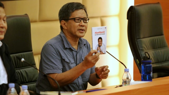 Rocky Gerung menunjukkan buku #kamioposisi di Kompleks Parlemen, Senayan, Jakarta, Selasa (4/2). Foto: Irfan Adi Saputra/kumparan