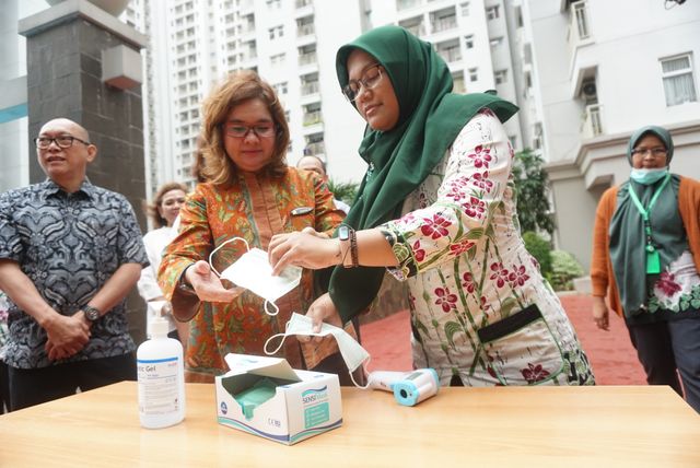 Petugas Dinkes DKI Jakarta memberikan masker kepada penghuni di Apartemen Mediterania, Jakarta, Kamis (6/2). Foto: Iqbal Firdaus/kumparan