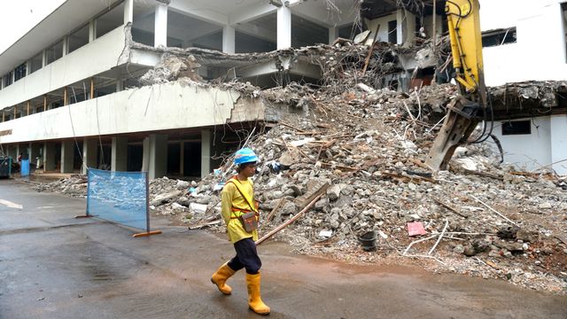 Pekerja berjalan di dekat ekskavator yang melakukan pembongkaran gedung Graha Bhakti Budaya (GBB) Taman Ismail Marzuki (TIM), Jakarta, Kamis (6/2). Foto: Iqbal Firdaus/kumparan