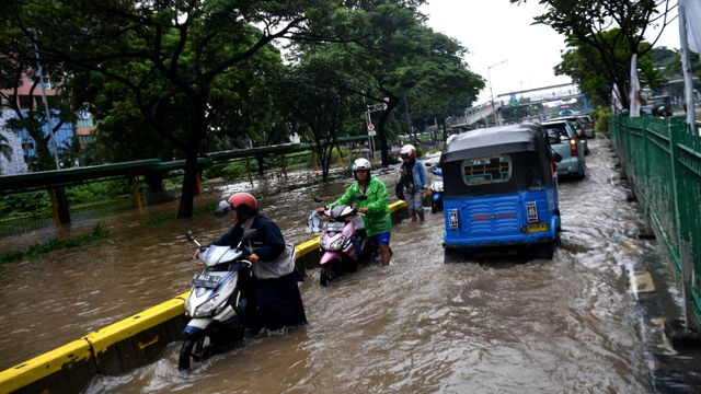 Warga mendorong motornya yang mogok saat melintasi banjir di Jalan Letjen Suprapto, Jakarta Pusat, Sabtu (8/2).  Foto: ANTARA FOTO/Sigid Kurniawan