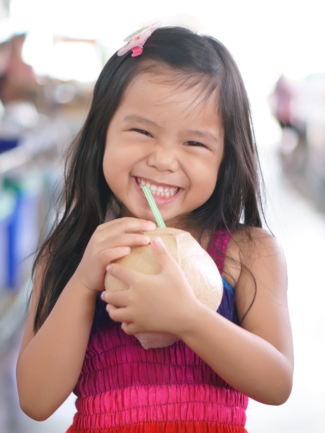 Ilustrasi anak minum air kelapa. Foto: Shutter Stock
