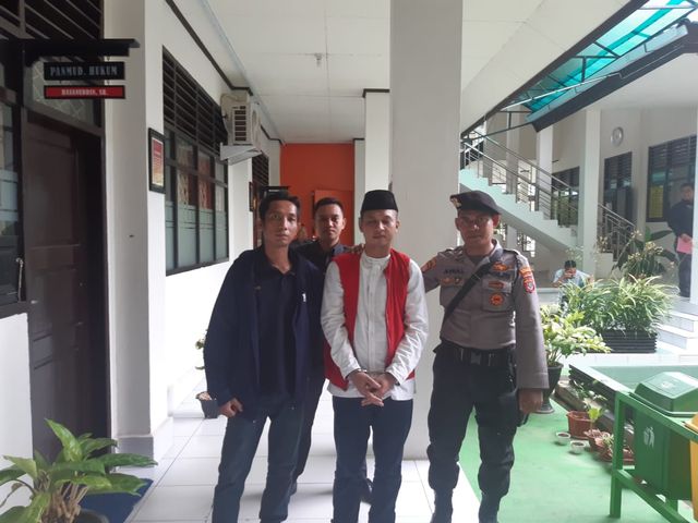 Achfi Suhasim (tengah), terdakwa pembunuh presenter TVRI Kendari, Aditia saat akan menjalani sidang. Foto: Wiwid Abid Abadi/kendarinesia