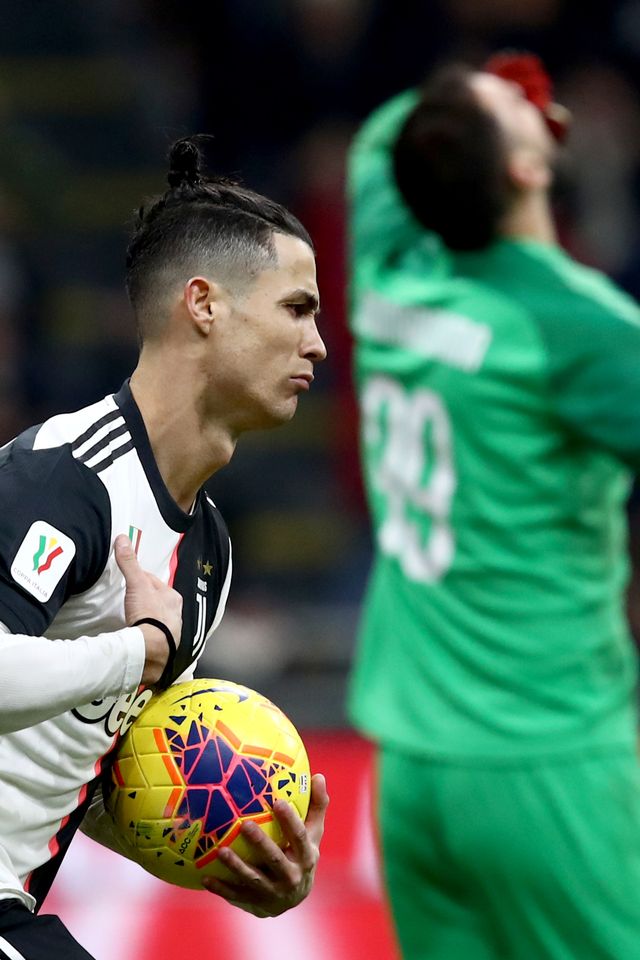 Cristiano Ronaldo membawa bola saat selebrasi usai mencetak gol penalti saat melawan AC Milan. Foto: AFP/ISABELLA BONOTTO