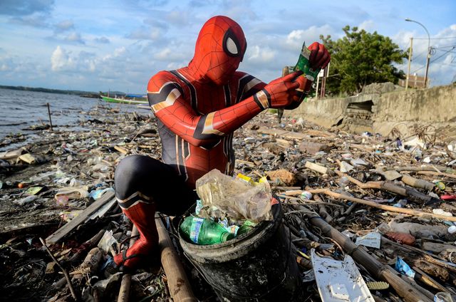Rudi Hartono, seorang pria berpakaian kostum Spiderman, mengumpulkan sampah di sebuah pantai di Pare-Pare, provinsi Sulawesi Selatan, Indonesia. Foto: REUTERS/Stringer