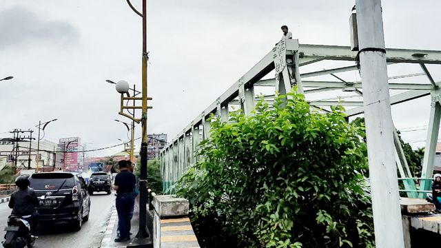 Seorang pria yang diduga stres memanjat ke atas Jembatan Andalas, Kota Padang, Sumatera Barat (Foto: Adi S/Langkan.id)