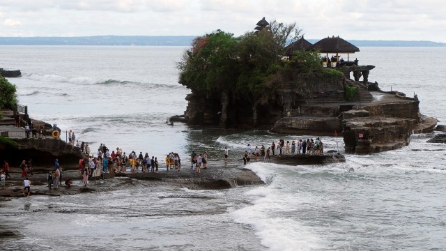 Wisatawan beraktivitas di Pantai Tanah Lot, Tabanan, Bali. Foto: ANTARA FOTO/Nyoman Hendra Wibowo