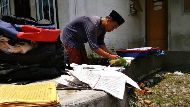 Santri di Pondok Pesantren di Jember, mengeringkan kitab dan barang-barang yang terendam banjir.  Foto: kumparan