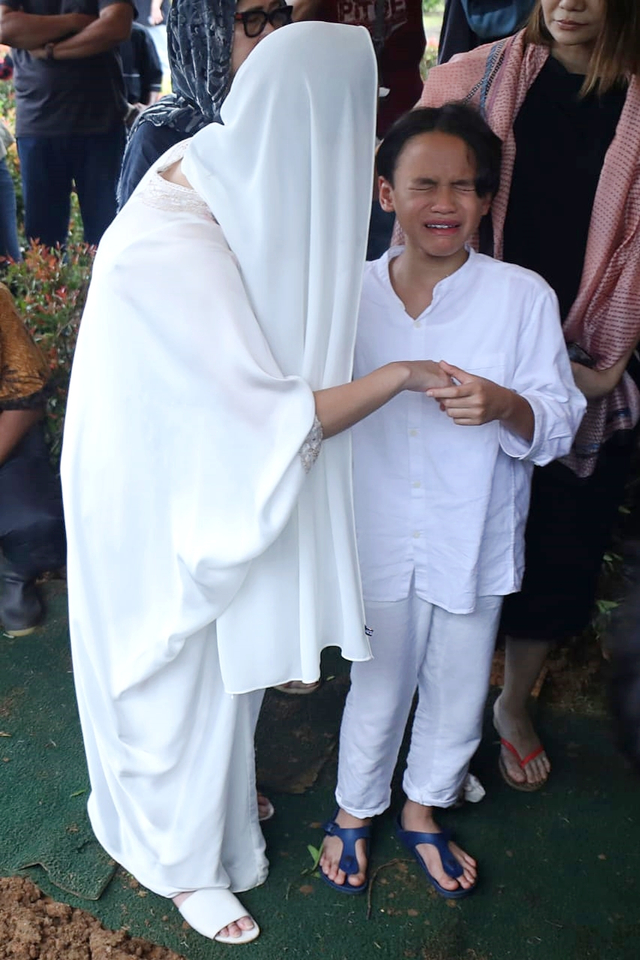 Bunga Citra Lestari menenangkan anaknya, Noah Sinclair, saat pemakaman Ashraf Sinclair, di San Diego Hill Memorial Park, Karawang. Foto: Fanny Kusumawardhani/kumparan