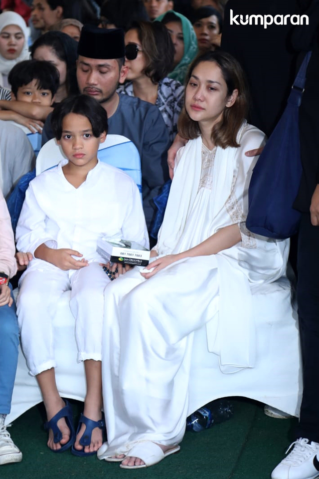Bunga Citra Lestari bersama anaknya, Noah Sinclair, saat prosesi pemakaman Ashraf Sinclair di San Diego Hills.
 Foto: Fanny Kusumawardhani/kumparan