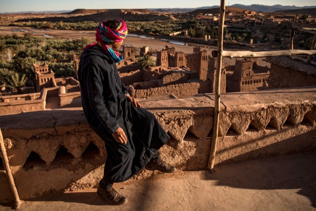 Seorang pria duduk di atas Kasbah (benteng kuno) Ait-Ben-Haddou, yang menggambarkan kota fiksi Yunkai dari serial televisi HBO "Game of Thrones". Foto: FADEL SENNA / AFP