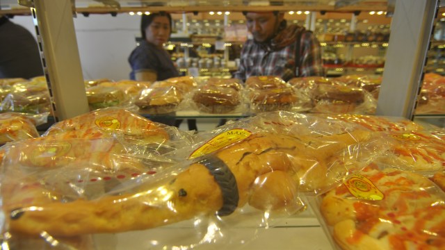 Roti berbentuk seekor buaya terjerat ban berukuran kecil. Foto: ANTARA FOTO/Mohamad Hamzah