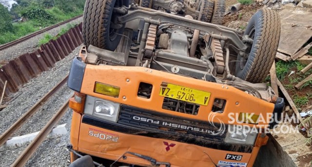 Dump truck pengangkut batu terperosok ke proyek double track di Kampung Cibeber RT 02/03, Desa Tenjoayu, Kecamatan Cicurug, Kabupaten Sukabumi, Selasa (18/2/2020) malam. Evakuasi akan dilakukan setelah KA terakhir dari Bogor menuju Sukabumi melintas, Rabu | Sumber Foto: Syahrul Himawan