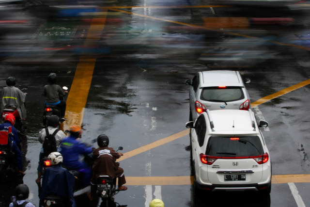 Pengendara kendaraan bermotor berhenti di lampu merah perempatan Jalan Darmo-Jalan Pandegiling, Surabaya, Jawa Timur, Rabu (19/2). Foto: ANTARA FOTO/Didik Suhartono