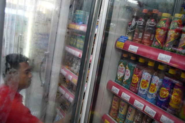 Karyawan menyusun minuman kemasan di salah satu gerai Alfamart di Palembang, Sumatera Selatan, Kamis (20/2). Foto:  ANTARA FOTO/Nova Wahyud