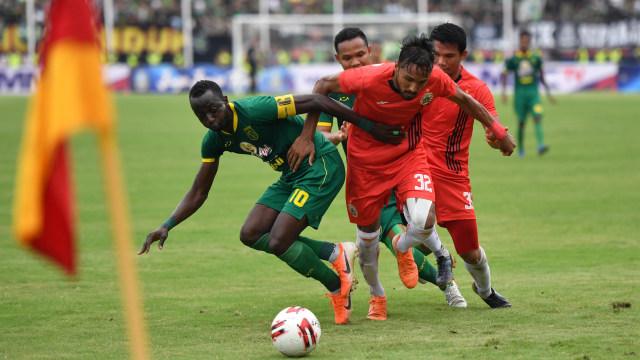 Pemain Persebaya Makan Konate berebut bola dengan penjaga gawang Persija Jakarta pada pertandingan final Piala Gubernur Jatim 2020 di Gelora Delta Sidoarjo. Foto: ANTARA FOTO/Zabur Karuru