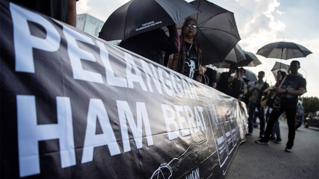 Aktivis membentangkan spanduk bertuliskan "Pelanggaran HAM Berat" di Aksi Kamisan ke-573 di depan Istana Negara, Jakarta, Kamis (7/2/2019). Foto: Irfan Adi Saputra/kumparan