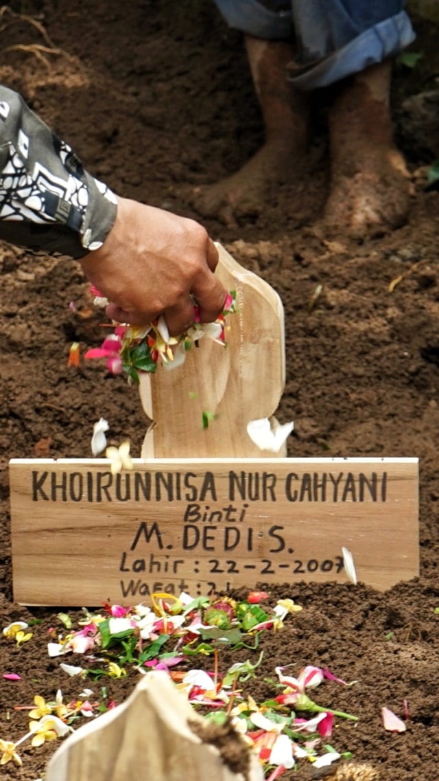 Keluarga menaburkan bunga saat prosesi pemakaman Khoirunnisa Nurcahyani di Girikerto, Turi, Sleman, D.I Yogyakarta, Sabtu (22/2). Foto: ANTARA FOTO/Andreas Fitri Atmoko