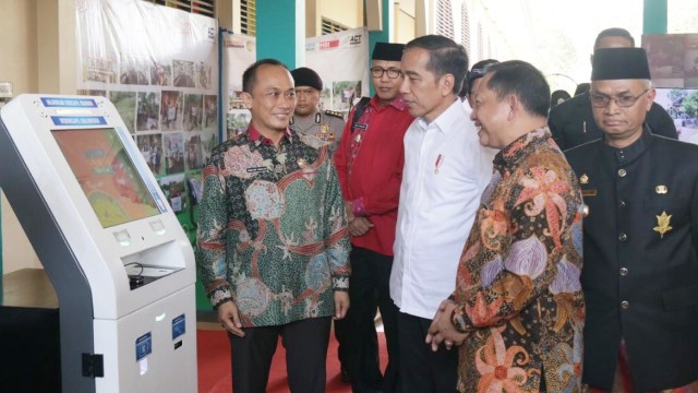 Presiden Joko Widodo (tengah) meninjau mesin Anjungan Dukcapil Mandiri (ADM) di Sekolah Sukma Bangsa, Bireuen, Aceh, Sabtu (22/2). Foto: Dok. Kemendagri