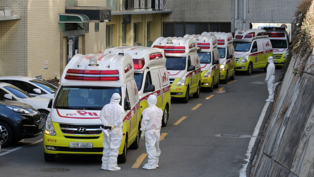 Ambulans yang mengangkut pasien coronavirus yang dikonfirmasi tiba di luar rumah sakit di Kota Daegu, Korea Selatan, Minggu (23/2). Foto: Reuters