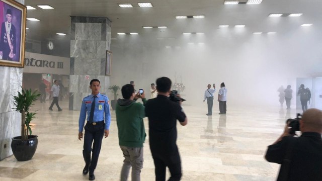 Sejumlah orang memotret kepulan asap di Gedung Nusantara III, Jakarta, Senin (24/2). Foto: Raga Imam/kumparan