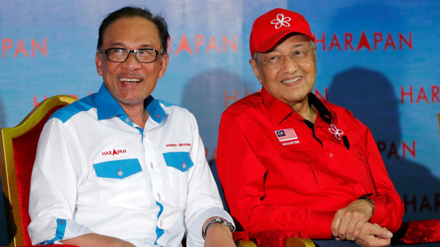 Perdana Menteri Malaysia Mahathir Mohamad, (kanan) duduk di sebelah ikon reformasi Malaysia Anwar Ibrahim selama rapat umum di Port Dickson.  Foto: AP Photo/Vincent Thian