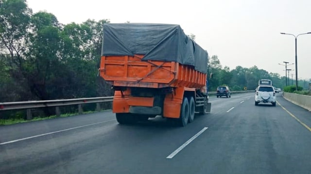 Truk yang kelebihan muatan atau over dimension over load (Odol) melintas di jalan tol. Foto: Dok. Joko Setiowarno