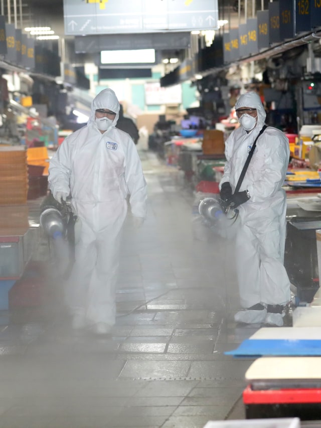 Petugas menyemprotkan disinfektan di pasar ikan di Busan, Korea Selatan. Foto: REUTERS
