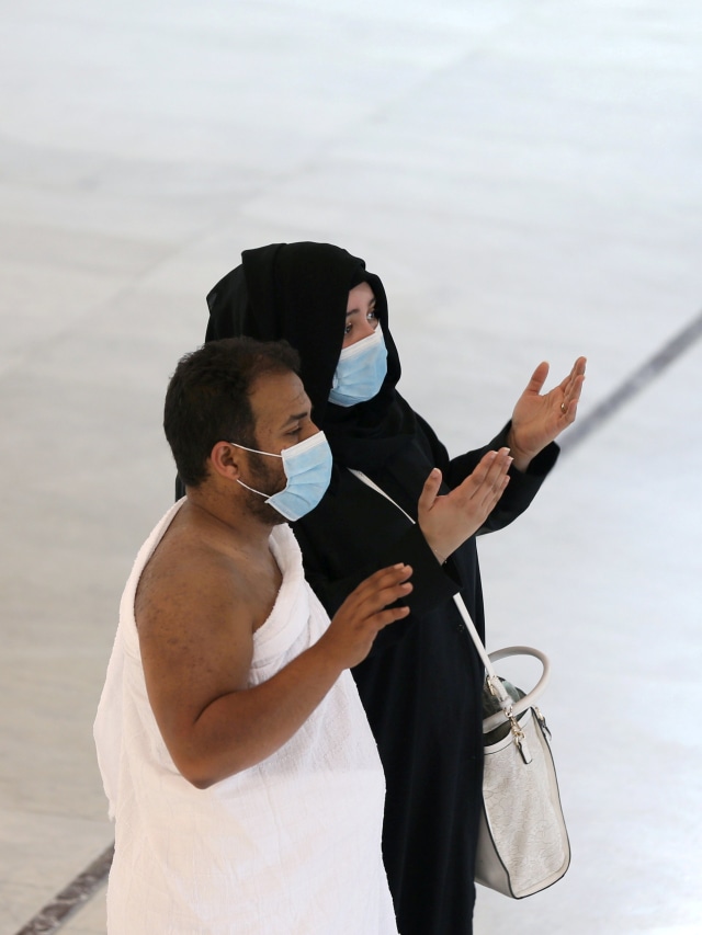 Jemaah Umrah berdoa sambil mengenakan masker untuk mencegah tertular virus corona di Masjidil Haram, Mekah, Arab Saudi. Foto: REUTERS/Ganoo Essa