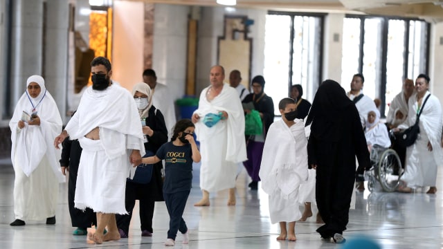 Jemaah Umrah mengenakan masker untuk mencegah tertular virus corona di Masjidil Haram, Mekah, Arab Saudi. Foto: REUTERS/Ganoo Essa
