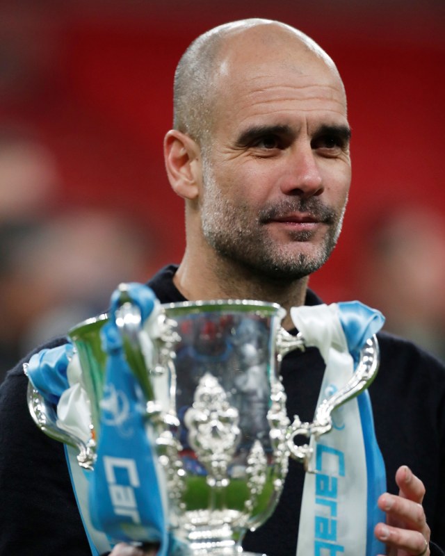 Pep Guardiola, pelatih Manchester City, menggenggam trofi Piala Liga Inggris. Foto: Reuters/Matthew Childs
