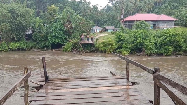 Kondisi jembatan di Desa Takana, Tobelo Timur, Halmahera Utara, Maluku Utara, ambruk diterjang arus sungai setelah hujan deras mengguyur. Foto: Nurkholis Lamaau/cermat
