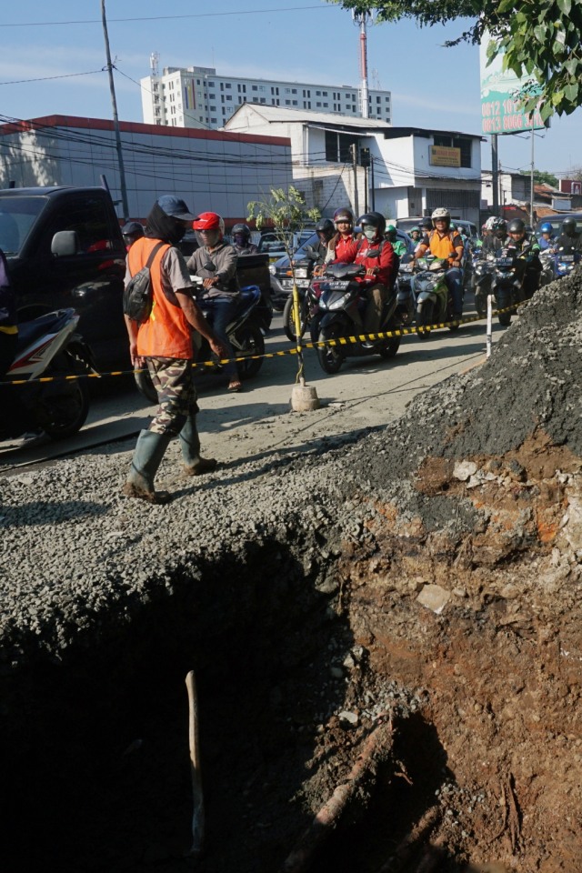 Pejalan kaki melintas di dekat jalan amblas di Jalan Daan Mogot KM 19.6 Tangerang, Banten, Senin (2/3). Foto: Fanny Kusumawardhani/kumparan