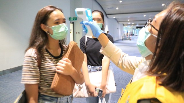 Petugas menggunakan thermal scanner memeriksa suhu tubuh penumpang di Bandara Soekarno-Hatta, Cengkareng, Senin (2/3). Foto: Dok. Angkasa Pura II