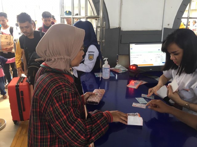 Petugas KAI mengecek tiket penumpang kereta Foto: Dok. PT KAI