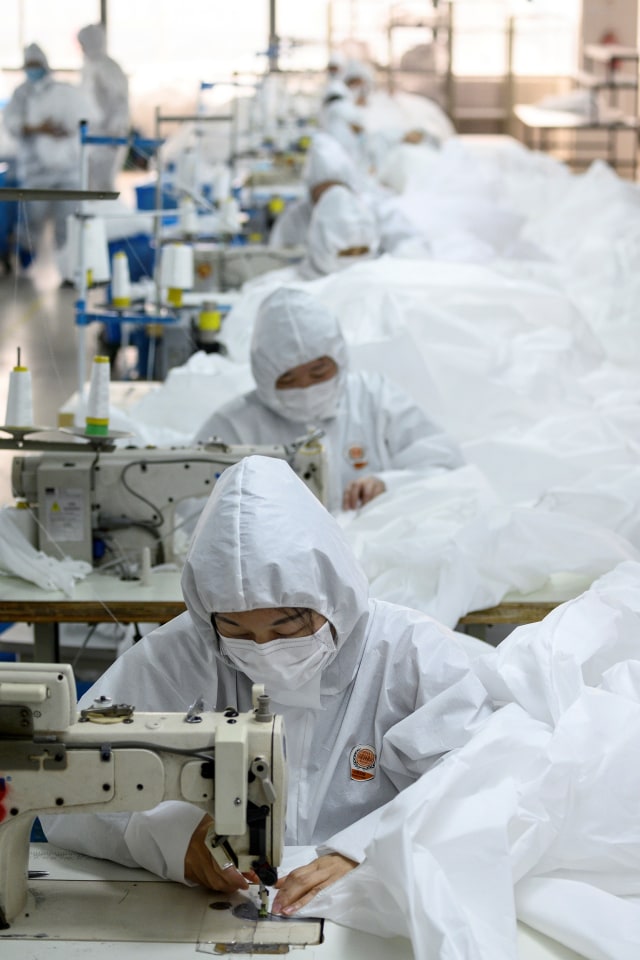 Pekerja menjahit kain untuk baju hazmat di pabrik garmen Zhejiang Ugly Duck Industry, di Wenzhou, China. Foto: AFP/NOEL CELIS
