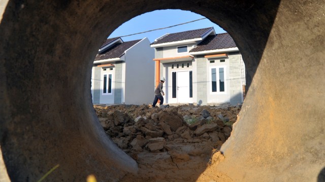 Pekerja melintas di depan Rumah untuk Milenial yang baru dibangun di kawasan Anduring, Padang, Sumatera Barat. Foto: Iggoy el Fitra/ANTARA FOTO