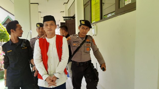 Achfi Suhasim (baju putih), terdakwa pembunuh presnter TVRI Kendari, Aditia, saat akan menjalani sidang putusan. Foto: Wiwid Abid Abadi/kendarinesia