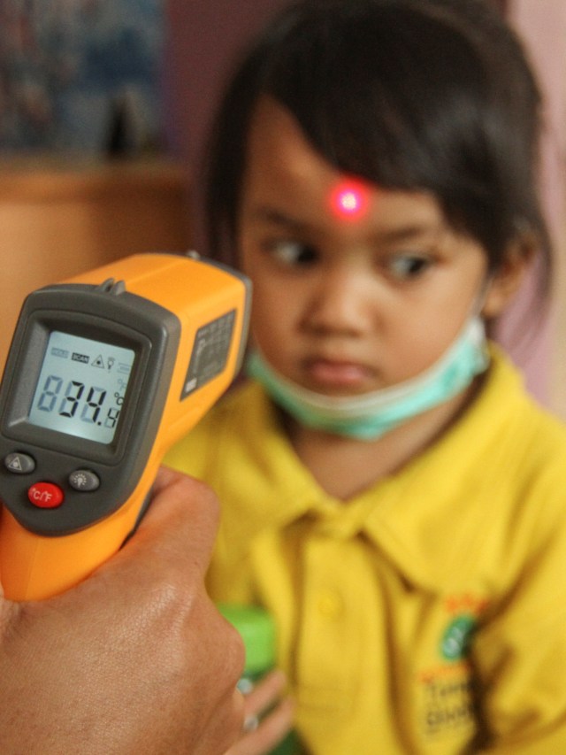 Petugas sekolah memeriksa suhu tubuh siswa menggunakan termometer non kontak saat sosialisasi di Sekolah Tunas Global, Depok. Foto: ANTARA FOTO/Asprilla Dwi Adha