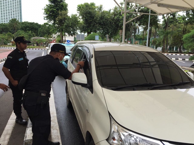 Pamdal DPR melakukan pengecekan suhu tubuh pengunjung untuk cegah corona. Foto: Paulina Herasmaranindar/kumparan