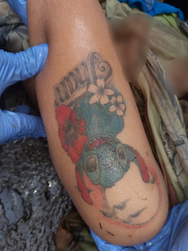 Petugas menunjukkan tato yang di tubuh mayat wanita yang ditemukan di Lembang, Foto: Dok. Istimewa