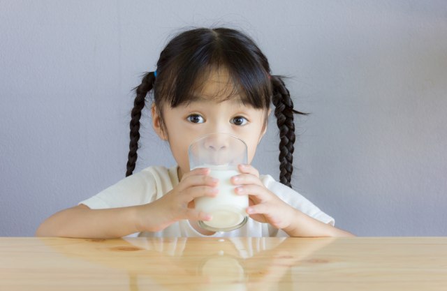 com-Ilustrasi anak minum susu penggemuk badan. Foto: Shutterstock