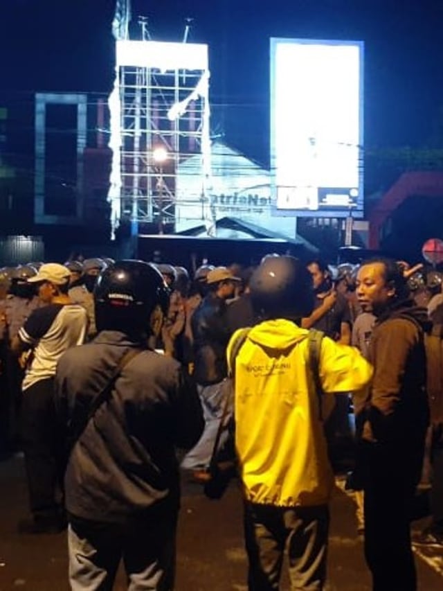 Polisi berjaga di lokasi bentrokan ojek online dan debt collector di Jalan Babarsari, Sleman. Foto: Arfiansyah Panji Purnadaru/kumparan