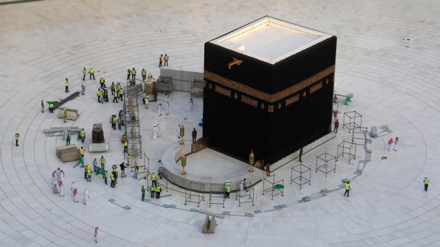 Sejumkah pekerja berada di dekat Ka'bah yang kosong dari pada jemaah di dalam Masjidil Haram, Arab Saudi, Kamis (5/3). Foto: AFP/ABDEL GHANI BASHIR