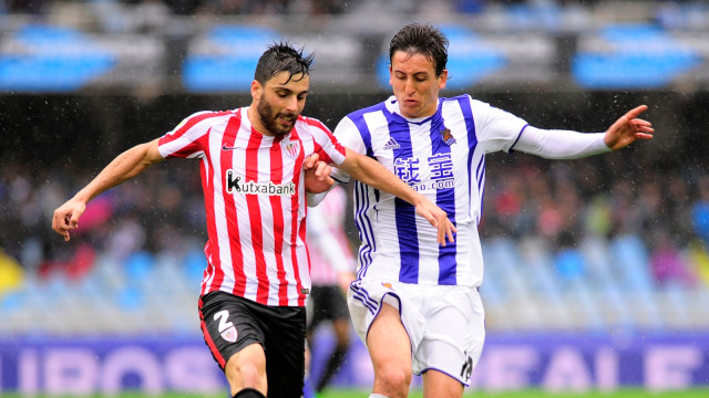 Pemain Athletic Club, Eneko Boveda (kiri), berduel denngan penyerang Real Sociedad, Mikel Oyarzabal. Foto: AFP/Ander Gillenea
