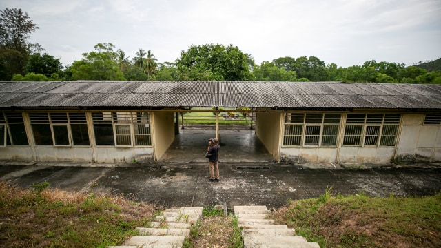 Warga melihat salah satu bangunan bekas rumah sakit di kawasan wisata Ex Camp Vietnam di Pulau Galang, Batam, Kepulauan Riau, Kamis (5/3). Foto: ANTARA FOTO/M N Kanwa