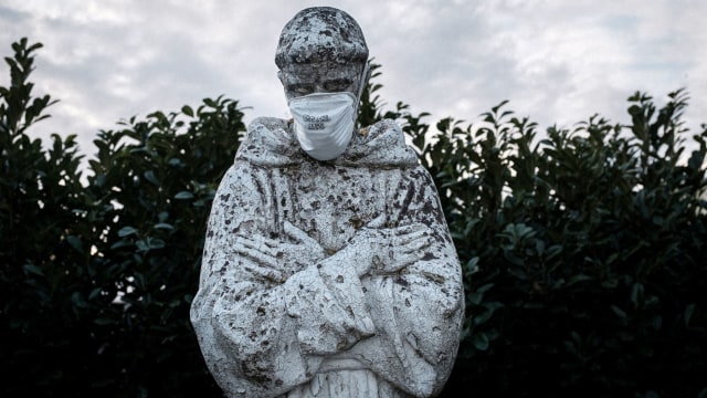 Patung santo pelindung Italia, St. Francis di San Fiorano dipasangi masker. Foto: Marzio Toniolo/via REUTERS