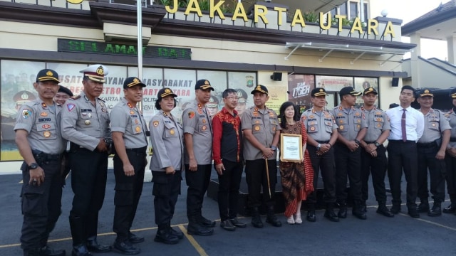 Anggota Polres Jakarta Utara foto bersama Indrayani dan Erwin usai penyerahan penghargaan karena menjual masker dengan harga normal. Foto: Helmi Afandi Abdullah/kumparan
