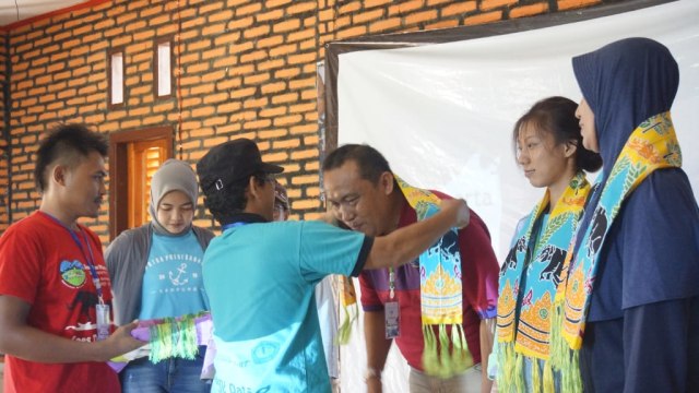 Ketua Pokdarwis Desa Labuhan Ratu VII, Basuki Rahmat, saat memberikan selendang kepada para tamu undangan Uji Coba Paket Wisata Desa Labuhan Ratu VII, Senin (9/3) | Foto: Dimas Prasetyo/Lampung Geh 